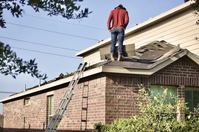 Professional roofer working on a residential roof in Hallbrook